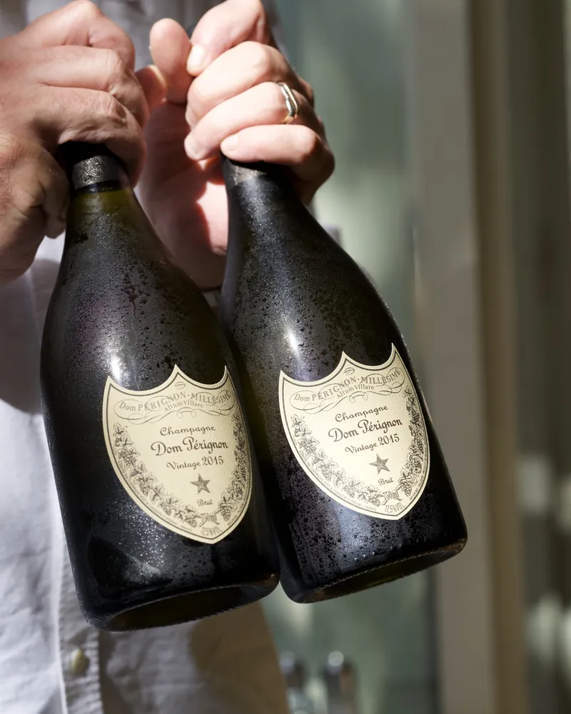 Deux bouteilles de champagne millésimé présentées par le service