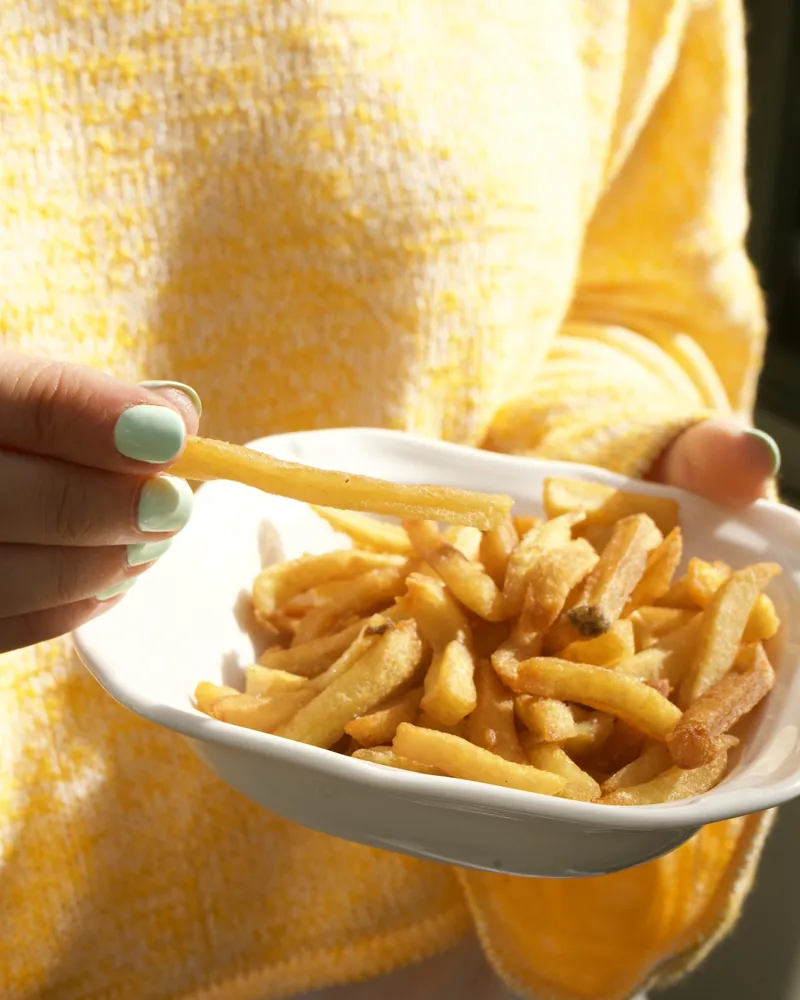Un bol de frites dorées, servies à la main